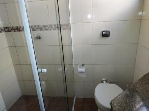 e bagno con servizi igienici e doccia in vetro. di Residencial Milton Prado a Florianópolis