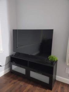 a black entertainment center with a large flat screen tv at Nice and cozy apartment in Ypsilanti