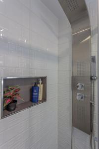 baño con ducha y estante con una planta en Céntrico apartamento Templo Quevedo Gran parking gratis, en Granada