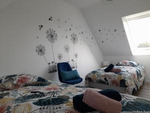 a bedroom with two beds and a blue chair at La casa Tata in Taulé