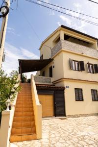 a house with a staircase in front of it at Apartman Marija in Lopar