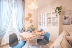a dining room with a table and blue chairs at Green Coast House 6 in Piombino