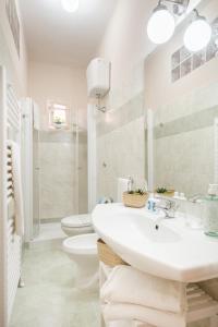a white bathroom with a sink and a toilet at Green Coast House 6 in Piombino