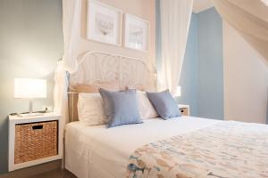 a bedroom with a large white bed with blue pillows at Green Coast House 6 in Piombino