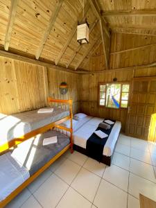 Duas camas num quarto com tecto em madeira em Pousada Lua de Java - Casa Bali em Praia do Rosa