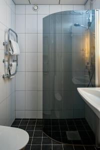 a bathroom with a shower and a toilet and a sink at Quality Hotel Statt in Hudiksvall