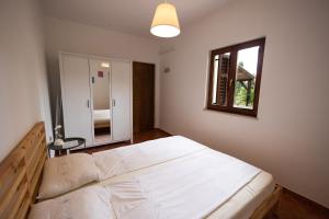 a bedroom with a large white bed and a window at Apartman Marija in Lopar