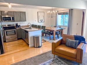 a kitchen and living room with a table and a couch at Remodeled Summit Condo at Snowshoe - Modern & Cozy in Snowshoe