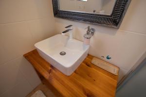 a bathroom with a sink on a wooden floor at Apartman Marija in Lopar