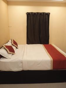 a bedroom with a large white bed with a window at The Royal Inn in Visakhapatnam