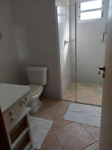 a bathroom with a toilet and a shower with a window at Casa Fuchsia Régia em Rancho Queimado/SC in Rancho Queimado