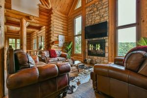a living room with leather furniture and a fireplace at Eagle's Nest in Saint-Faustin