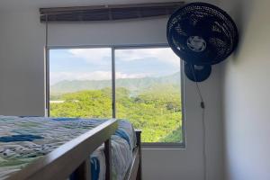 1 dormitorio con cama y ventana grande en Cómodo alojamiento cerca al Parque Tayrona, en Santa Marta