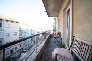 einen Balkon mit zwei Bänken und einem Fenster in der Unterkunft Freshly reno'd flat in between Lisbon and Sintra in Amadora