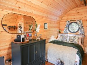 a bedroom with a bed in a wooden cabin at The Kites Nest in Ystrad Meurig