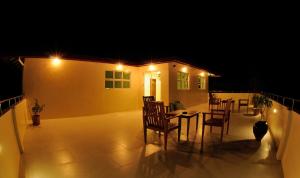 a patio with a table and chairs on a balcony at night at Antares Dhangethi & Spa in Dhangethi