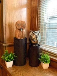 um par de estátuas sentadas numa prateleira com plantas em Whole House Cohassett em Lakewood