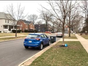 une voiture bleue garée sur le côté d'une rue dans l'établissement Whole House Cohassett, à Lakewood