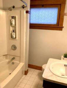 La salle de bains est pourvue d'un lavabo, d'une douche et de toilettes. dans l'établissement Whole House Cohassett, à Lakewood