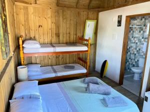 um quarto com 2 beliches e um WC em Pousada Lua de Java - Suíte Lombok em Praia do Rosa