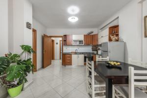 uma cozinha com uma mesa e um frigorífico em Brand New Apartment- Great location Seafront with pool access em Durrës