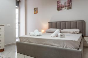 um quarto com uma cama grande e toalhas em Brand New Apartment- Great location Seafront with pool access em Durrës