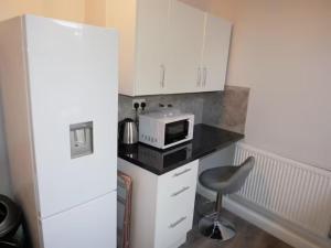 a kitchen with a white refrigerator and a microwave at Luxury Living Manchester in Manchester