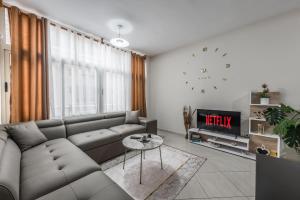 uma sala de estar com um sofá e uma televisão em Brand New Apartment- Great location Seafront with pool access em Durrës