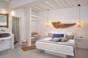Habitación blanca con cama y lavabo en Casa Tagoo Mykonos, en Tagou