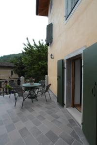 eine Terrasse mit einem Tisch und Stühlen neben einem Gebäude in der Unterkunft Albergo Diffuso Polcenigo P.Lacchin in Polcenigo