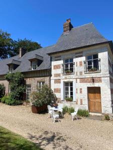 a large brick house with two white chairs in front of it at Gîtes Normands de charme les châtaigniers in Bretteville-du-Grand Caux