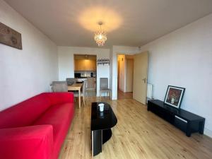 a living room with a red couch and a table at Ensuite Double Bedroom In Shared Apartment in Birmingham