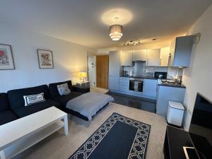 uma sala de estar com um sofá e uma cozinha em Etihad FC 2BR apartment with Water view em Manchester