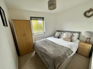 a small bedroom with a bed and a window at Etihad FC 2BR apartment with Water view in Manchester