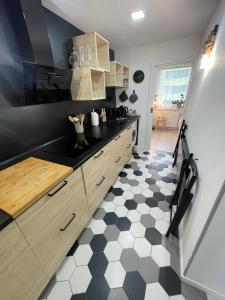 uma cozinha com piso em xadrez preto e branco em BYTEČEK U LESA em Hodonín