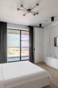 um quarto com uma grande cama branca e uma grande janela em Sea On Mamaia em Mamaia