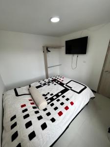 sypialnia z kołdrą na łóżku w obiekcie Centro Bogotá campanario w mieście Bogota