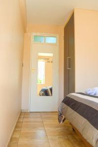 a bedroom with a bed and a door with a mirror at Fantastic location 1-Bed Apartment in Harare in Harare