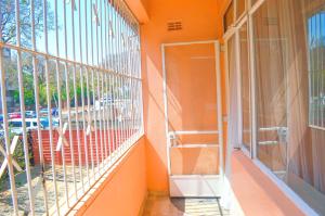 an orange facade of a building with a window at Fantastic location 1-Bed Apartment in Harare in Harare