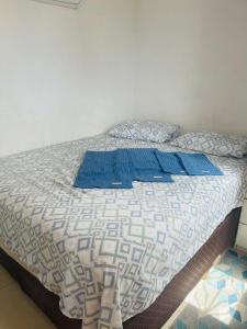um quarto com uma cama com almofadas azuis em Mini Casa Vista Mar em Salvador
