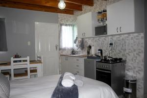 a kitchen with a bed and a sink and a stove at Villa La Sola B&B and Self-Catering in Boksburg
