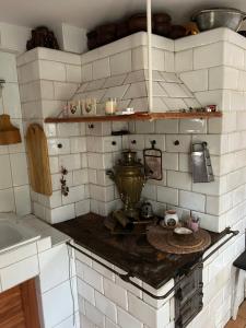 uma cozinha com paredes de azulejos brancos e um fogão em Stajnia Bukwica em Narewka