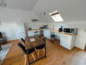 cocina con mesa y sillas en una habitación en Cosy appartement 2 chambres en Pont-de-lʼArche