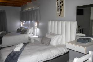 a bedroom with two beds and a desk at Villa La Sola B&B and Self-Catering in Boksburg