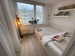 a small bedroom with a bed and a window at BYTEČEK U LESA in Hodonín