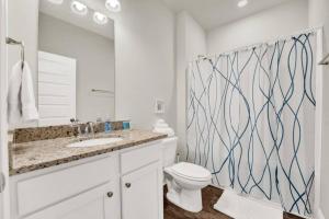 a bathroom with a sink and a toilet and a mirror at Joe's Beach House in Highland View +20 photos