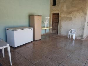 cocina con nevera, 2 sillas y mesa en Chacara dos ipes, en São Roque