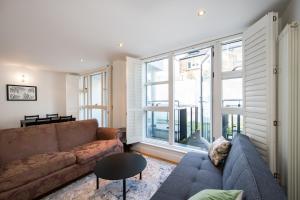 a living room with a couch and a large window at 2 Bed Flat in Clapham Common in London