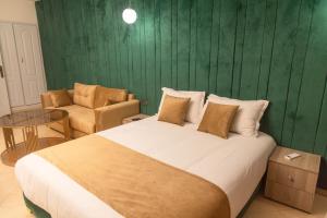 Un dormitorio con una cama grande y una pared verde en Residence La Perle de l'Atlas Marrakech, en Marrakech