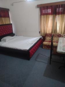 una piccola camera con letto e sedia di Taz Garden House a Dhaka